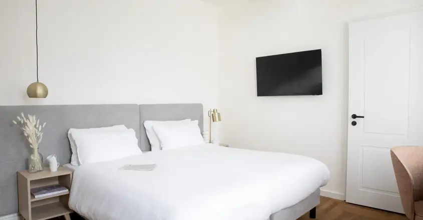 a bed with a tv on the wall