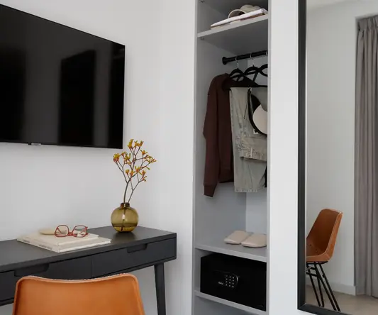 a room with a mirror and a shelf