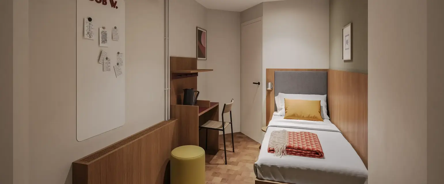 a small room with a bed and desk