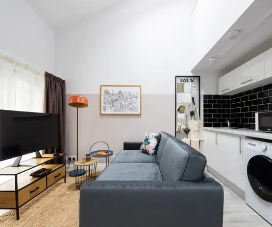 a living room with a couch and a washing machine