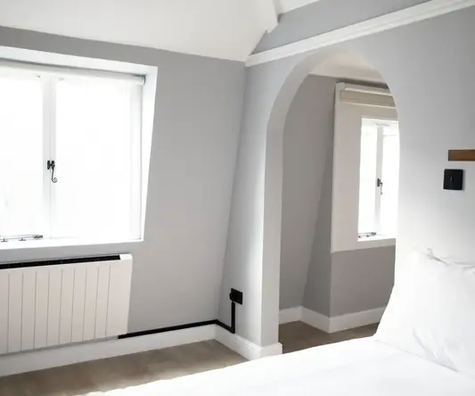 a bedroom with a white bed and a window