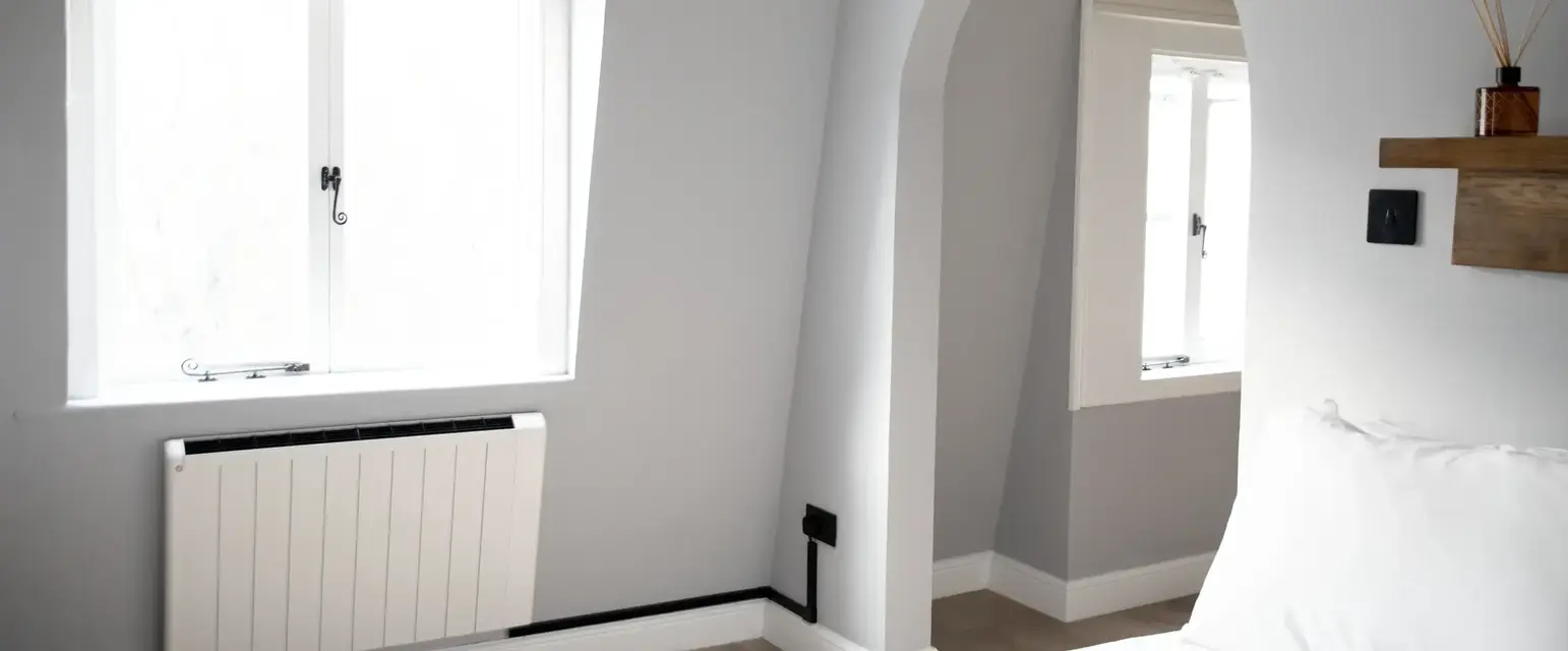 a bedroom with a white bed and a window