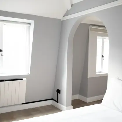 a bedroom with a white bed and a window