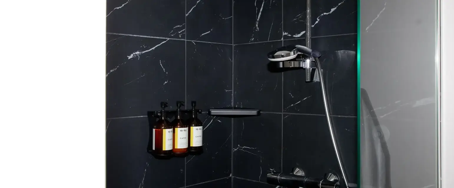 a shower with bottles of liquid on the wall