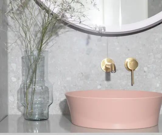 a pink sink with a vase of flowers