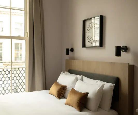 a bed with pillows and a window