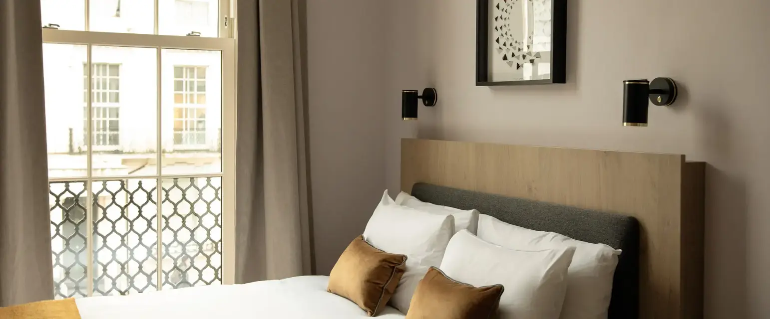 a bed with pillows and a window