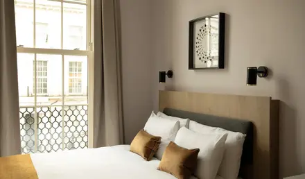 a bed with pillows and a window