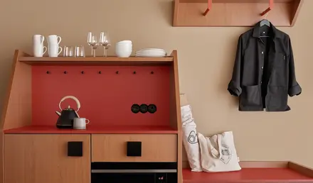 a kitchen with a black coat on a hook