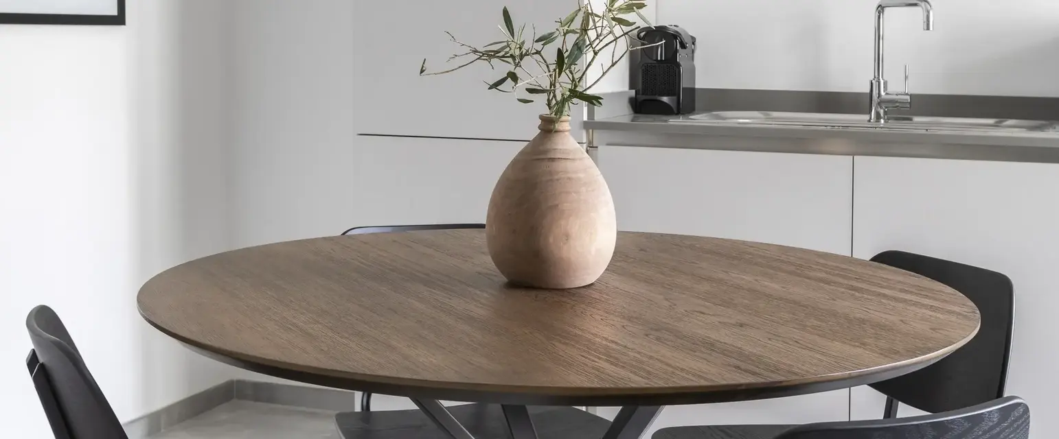 a table with chairs and a vase on it