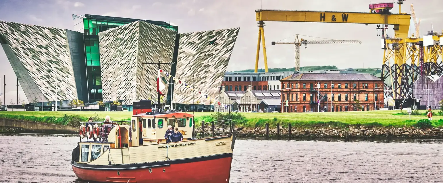 a boat in the water with the Titanic Experience in the background (Photo by K. Mitch Hodge on Unsplash)