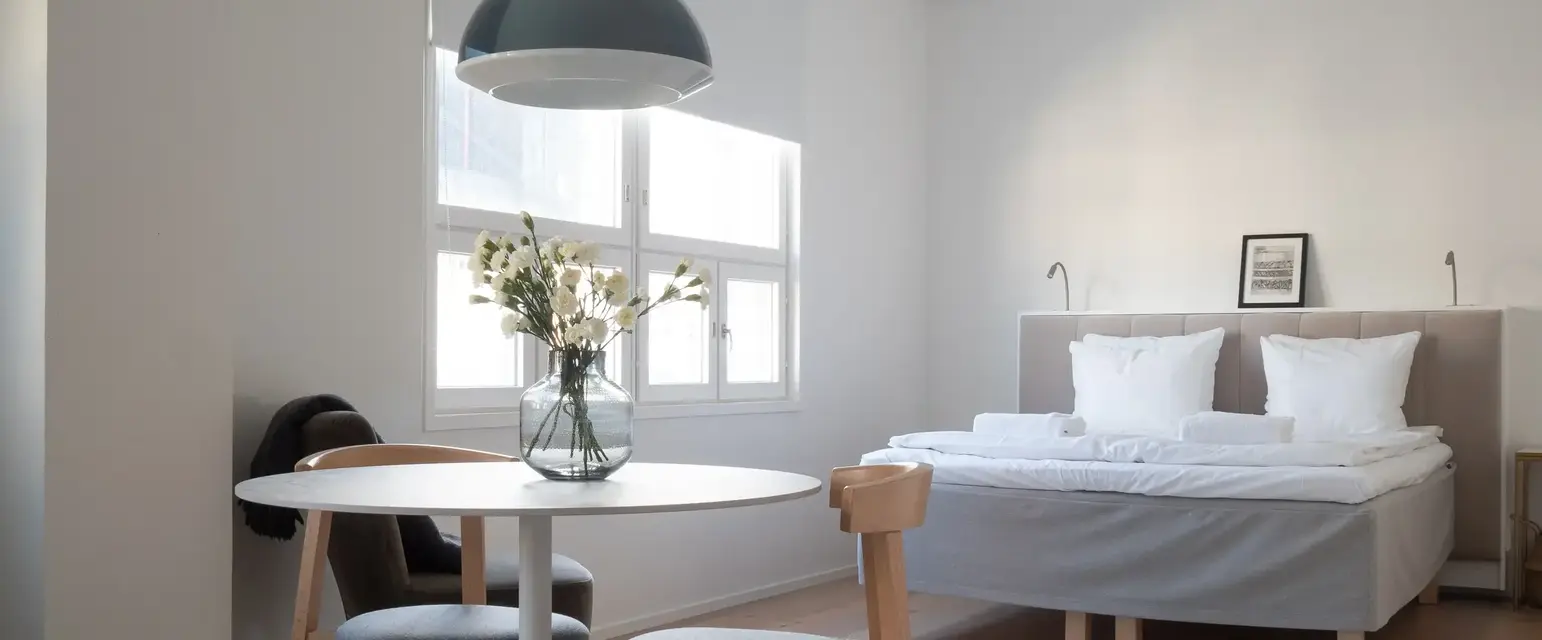 a room with a bed and a table and chairs