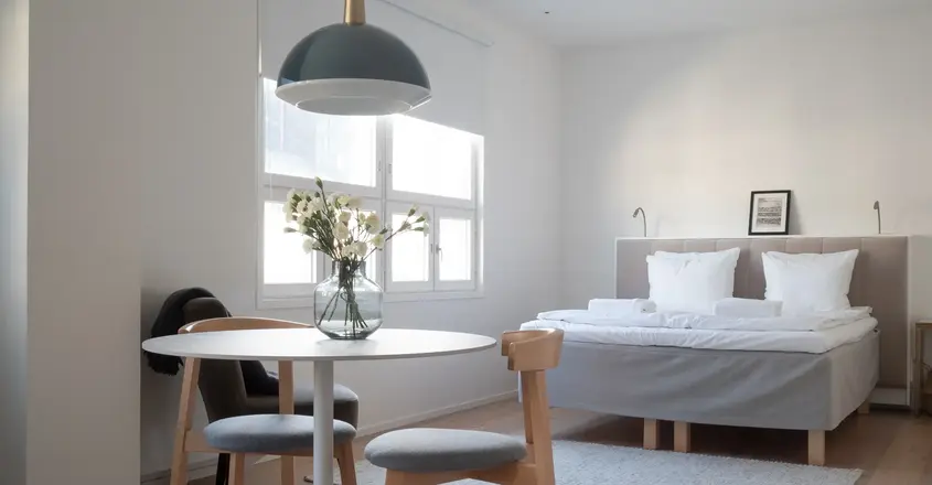 a room with a bed and a table and chairs