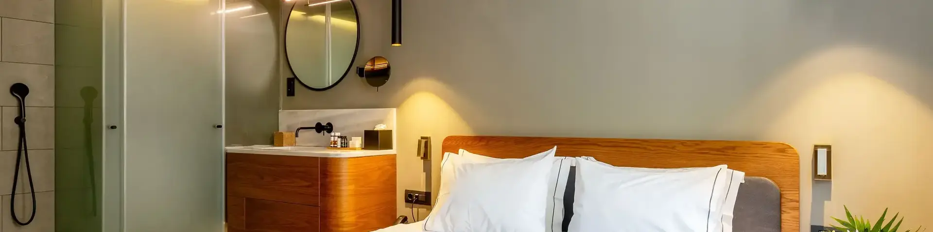 a bed with white sheets and a mirror in a room