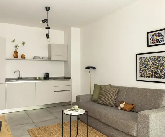 a living room with a couch and kitchen