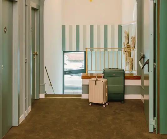 a hallway with a luggage and a chandelier