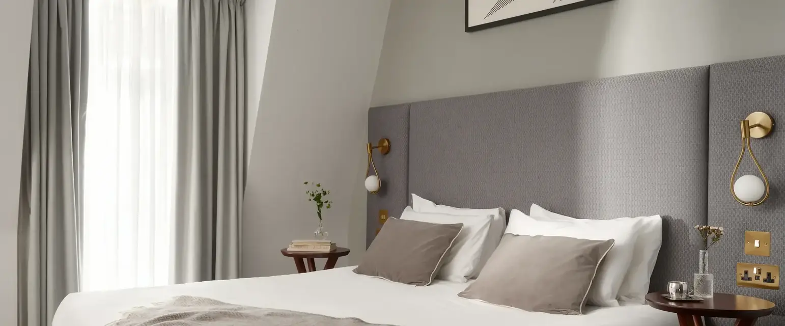 a bed with a blanket and a picture on the wall