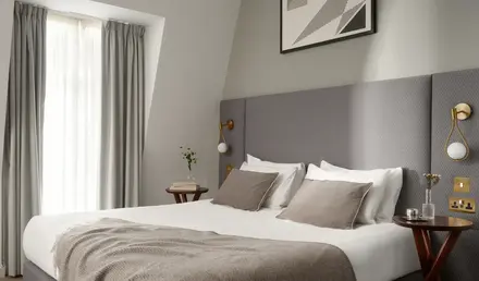 a bed with a blanket and a picture on the wall