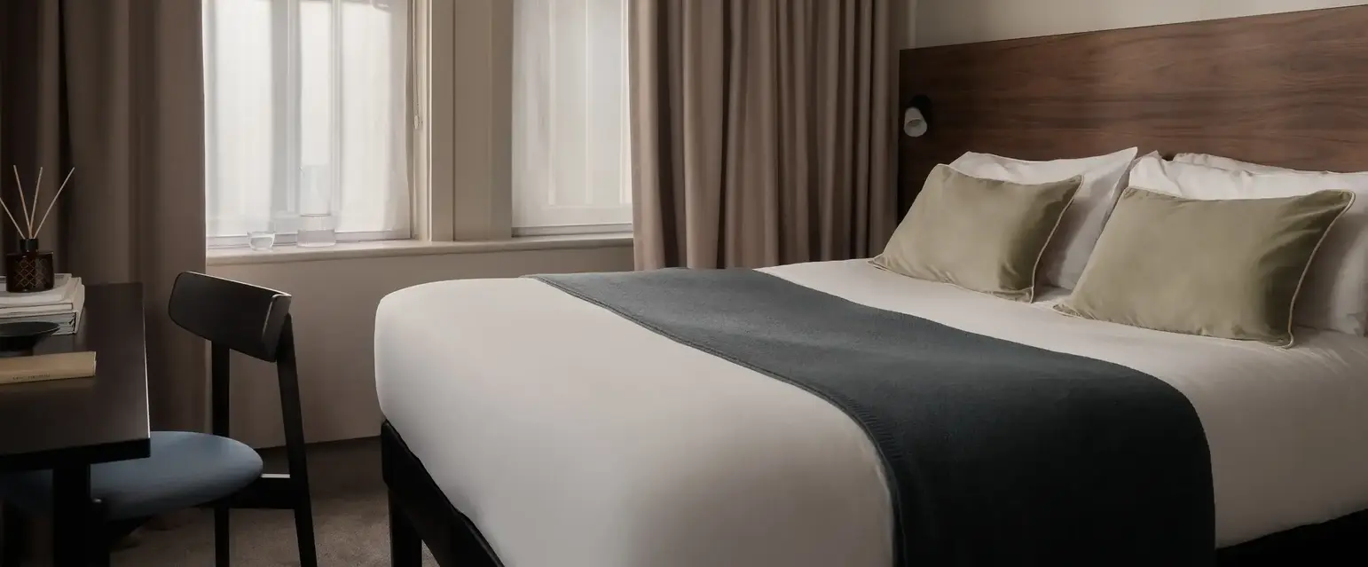 a bed with a chair and a chair in a room