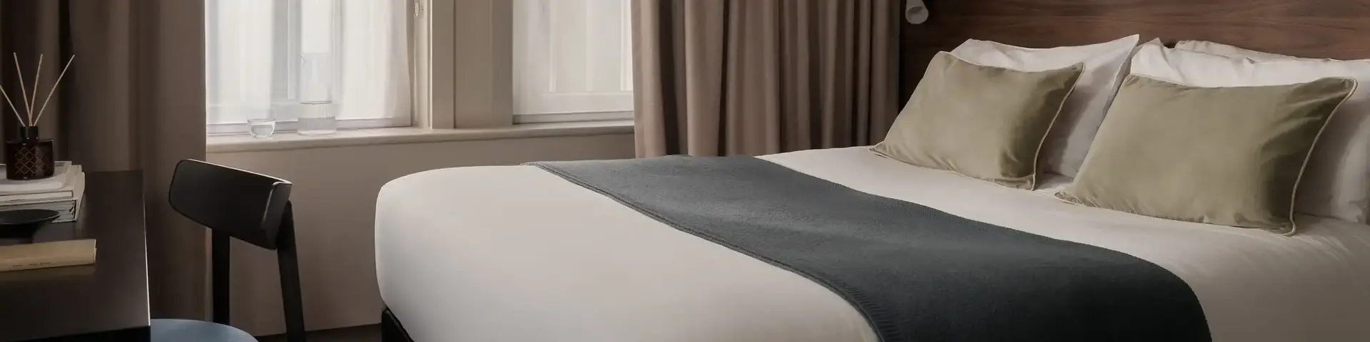 a bed with a chair and a chair in a room