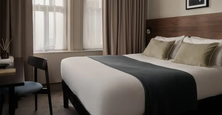 a bed with a chair and a chair in a room