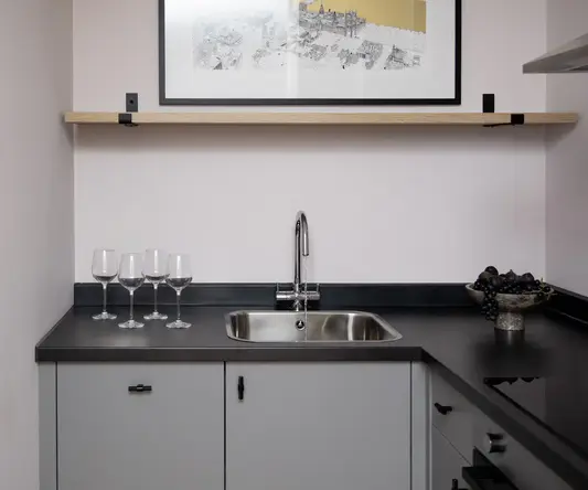 a sink and wine glasses on a counter