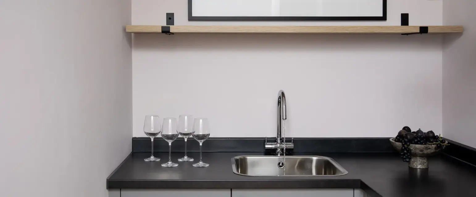 a sink and wine glasses on a counter