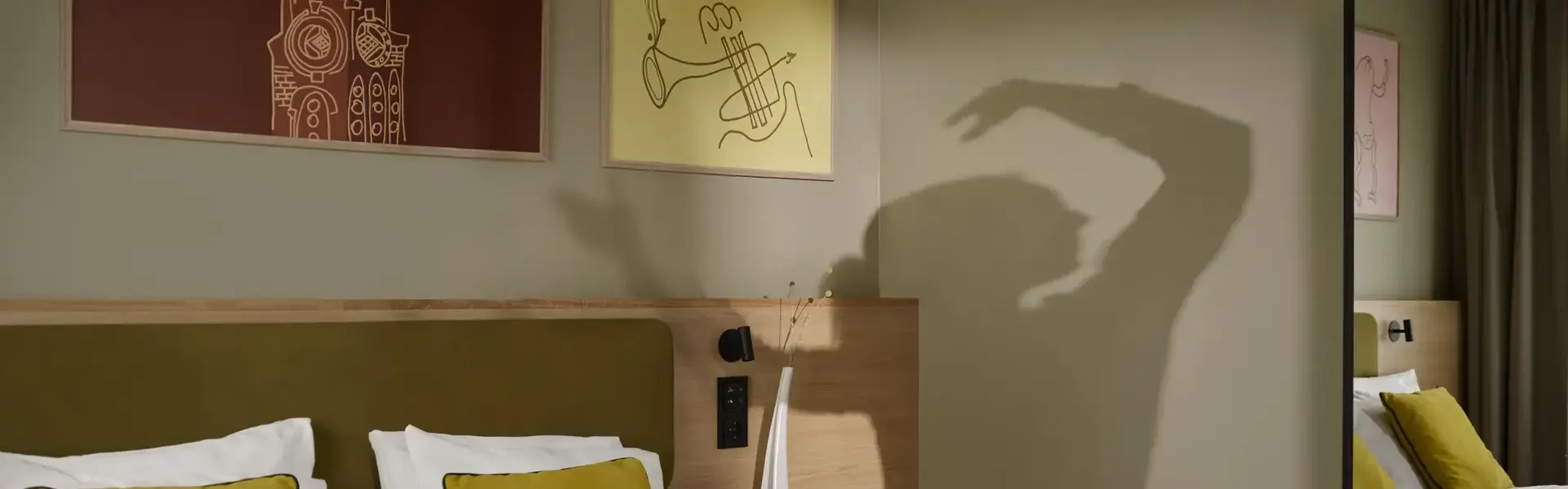 a bed with yellow pillows and a mirror in a room