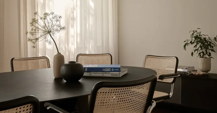 a table with chairs and a vase on it