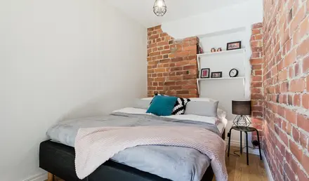 a bed with a brick wall behind it