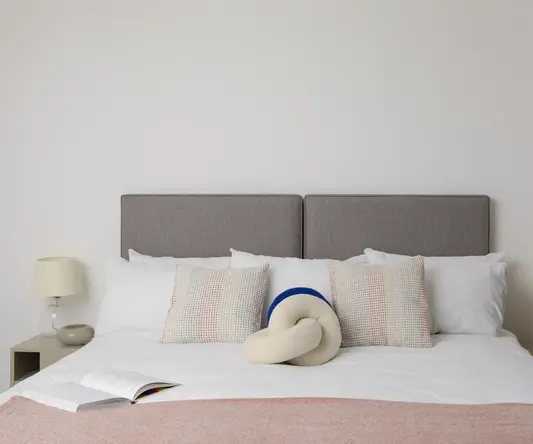 a bed with pillows and a book