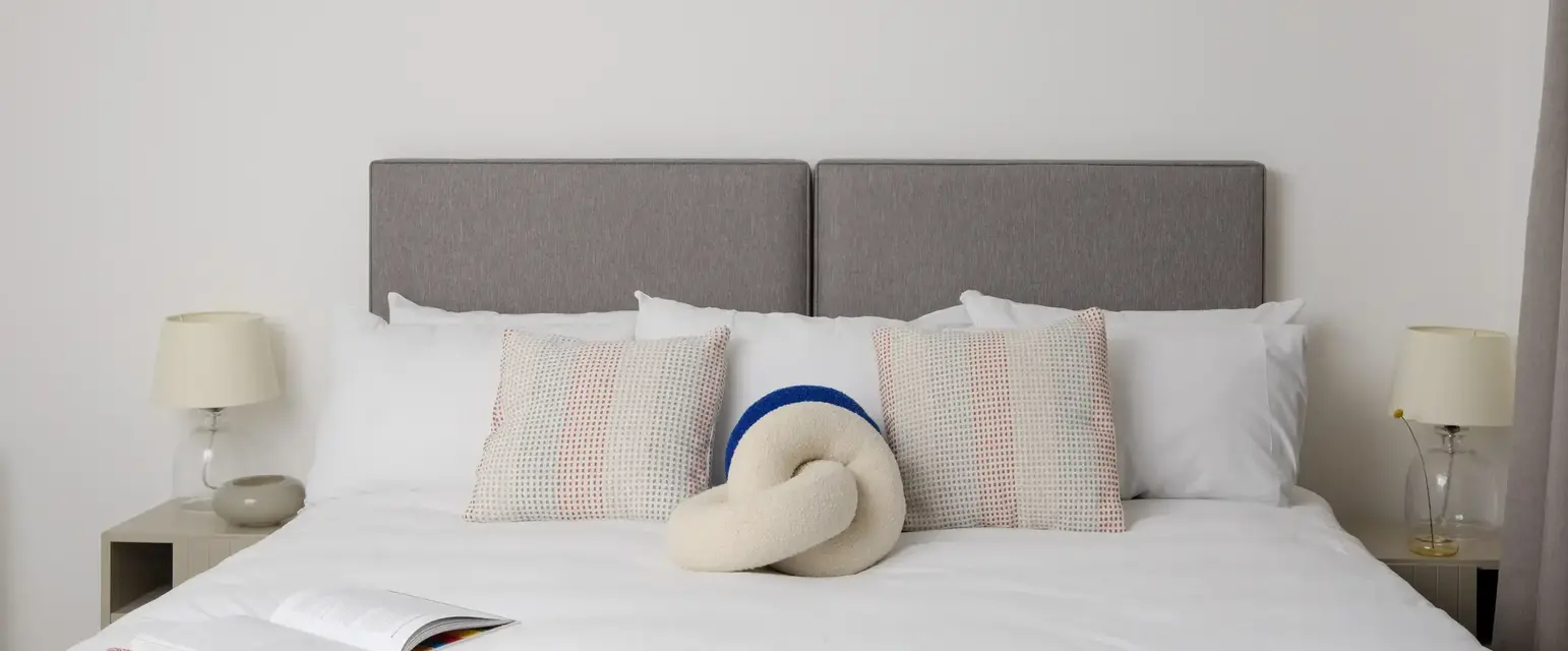 a bed with pillows and a book