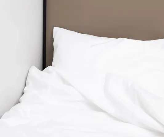a white pillow on a bed