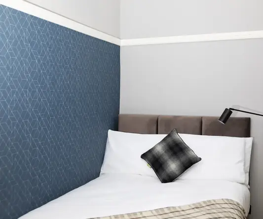 a bed with a pillow and a lamp