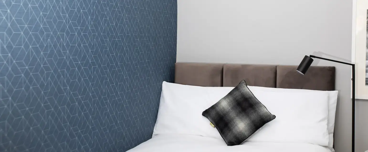 a bed with a pillow and a lamp