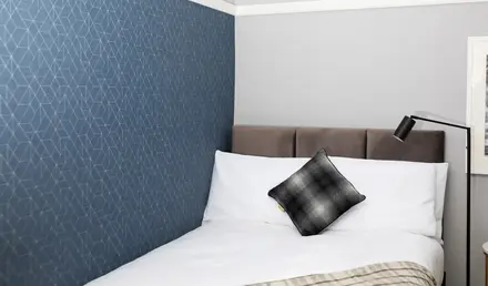 a bed with a pillow and a lamp