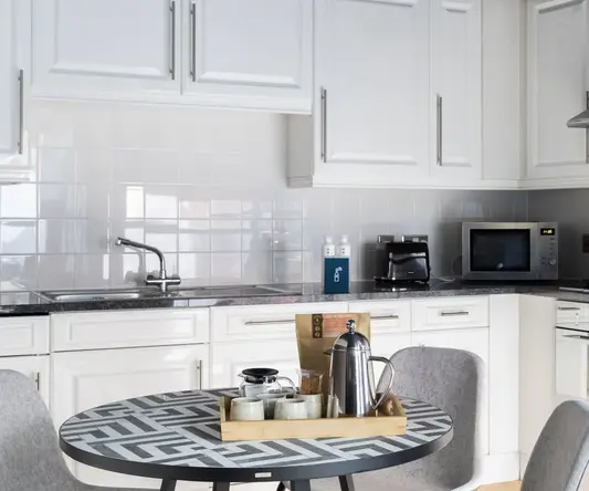 a kitchen with white cabinets and a table