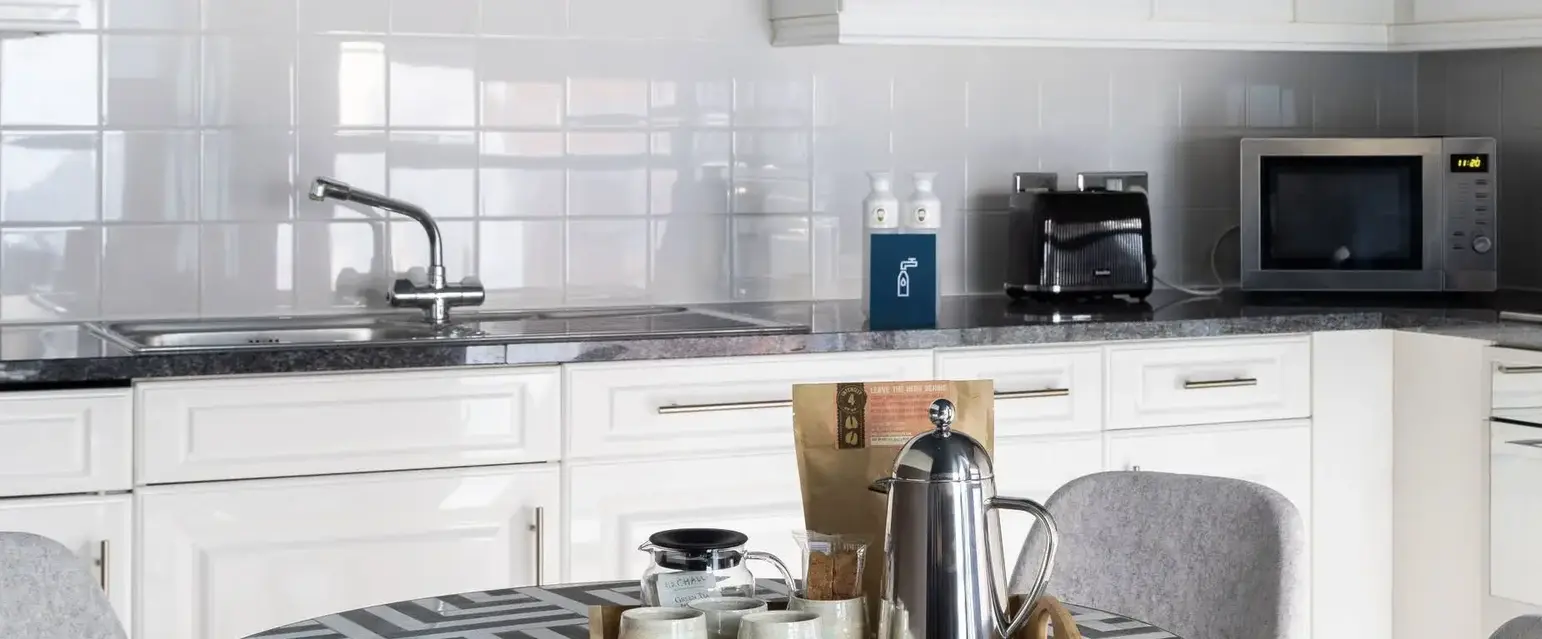 a kitchen with white cabinets and a table