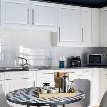 a kitchen with white cabinets and a table