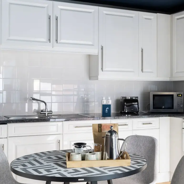 a kitchen with white cabinets and a table