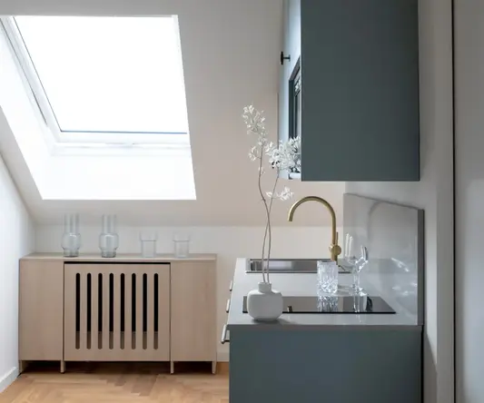 a kitchen with a sink and a vase of flowers