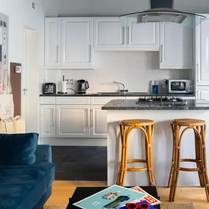 a kitchen with white cabinets and a black countertop