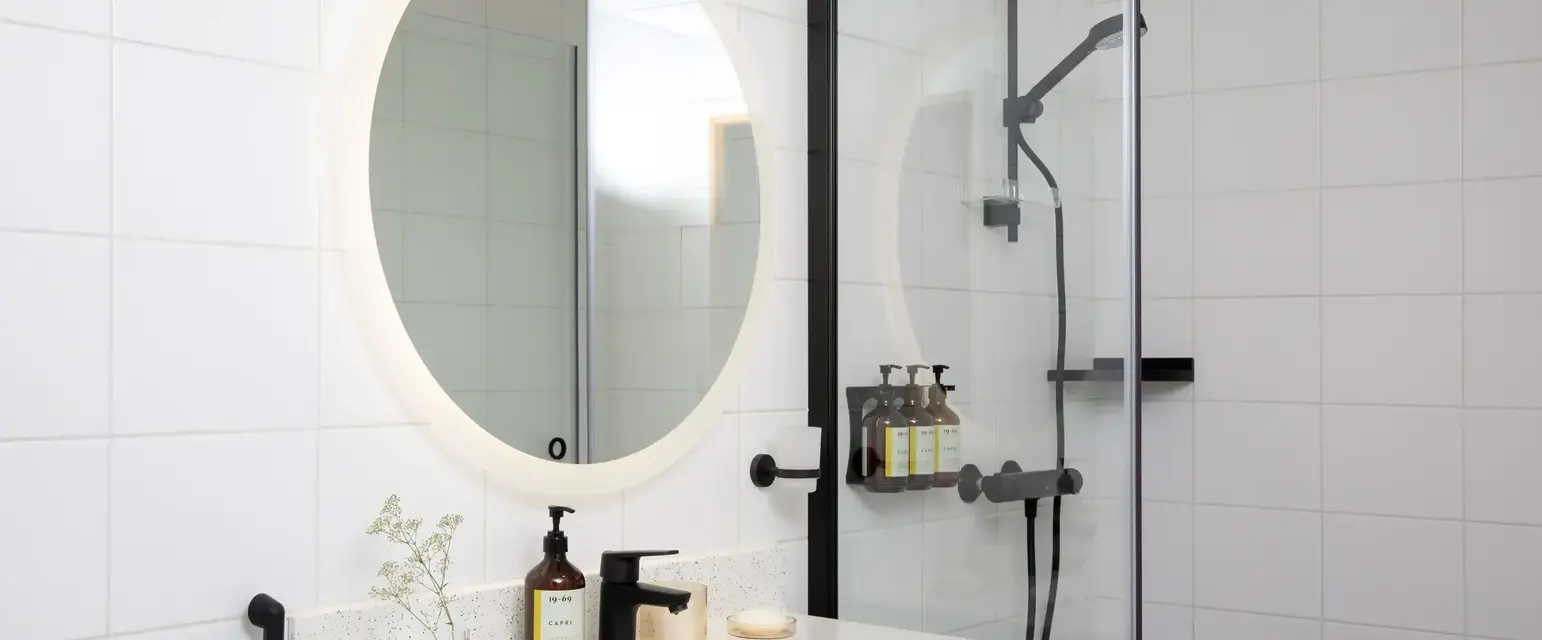 a bathroom with a round mirror and a sink