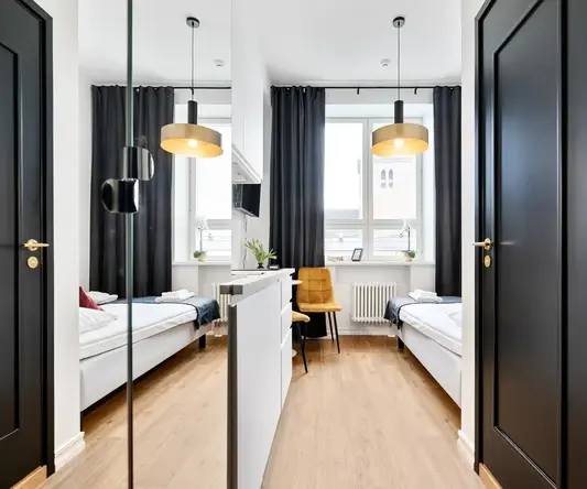 a room with two beds and a black door