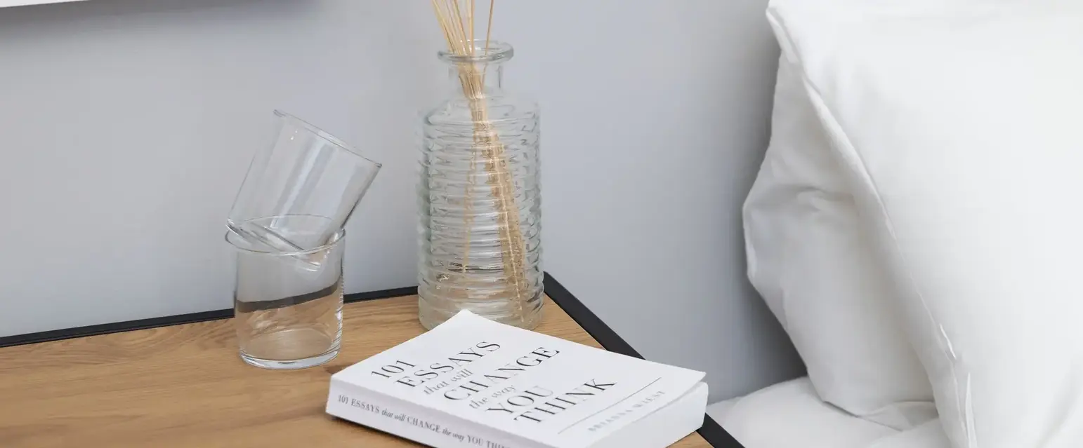 a table with a book and a vase of flowers on it