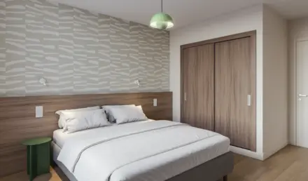 a bed with a wood cabinet and a green light from the ceiling