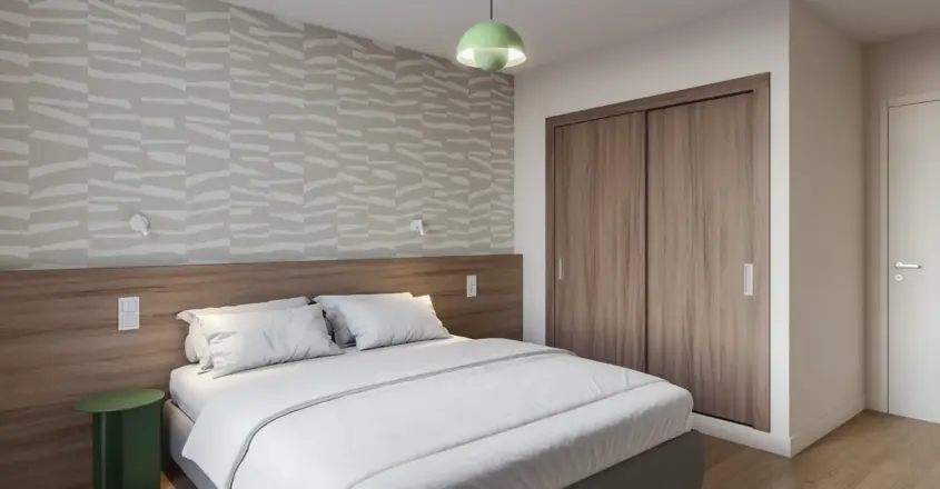 a bed with a wood cabinet and a green light from the ceiling