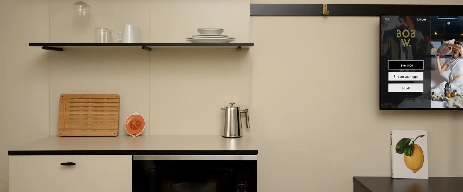 a kitchen with a microwave and a poster