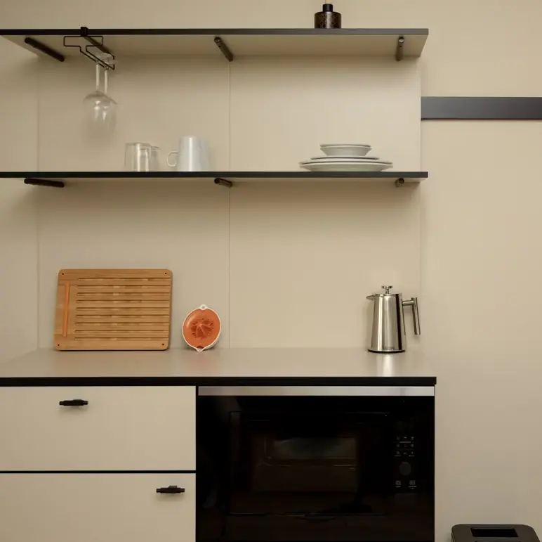 a kitchen with a microwave and a poster