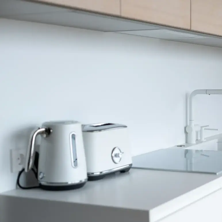 a kitchen counter with a toaster and a laptop